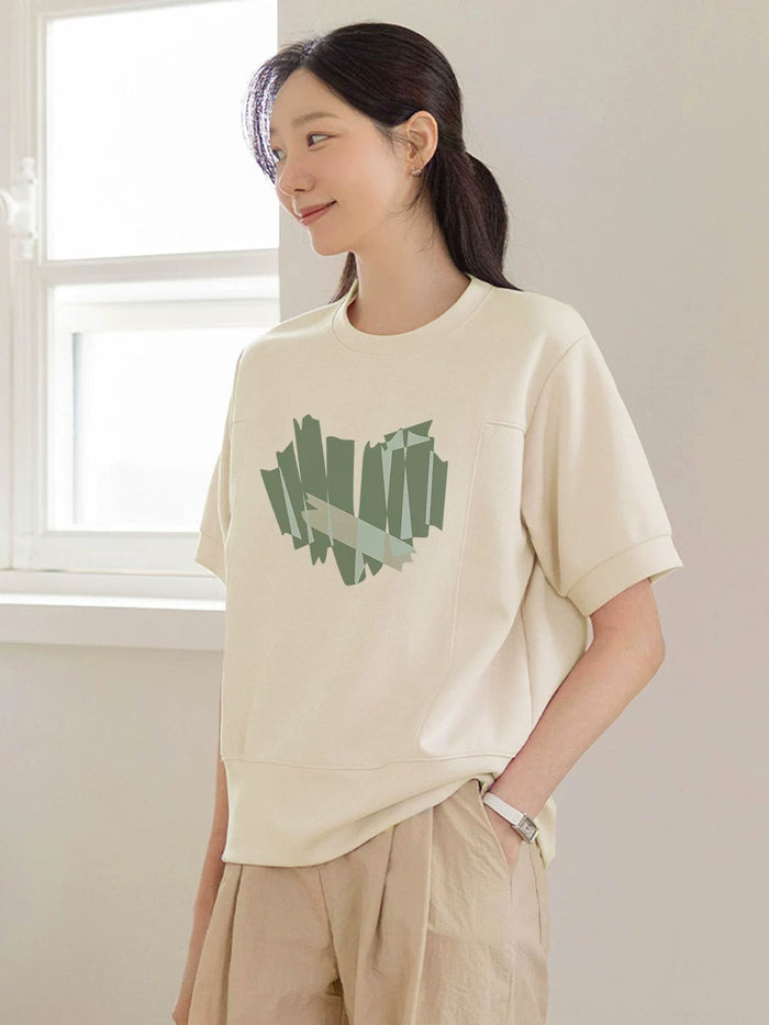 クリームのグリーンハート柄半袖Tシャツ 着用 手をポケットに