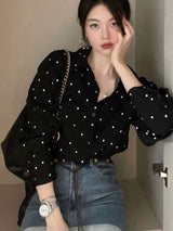 ブラックのドット柄シフォンシャツ 着用 頬に手を添えたポーズ