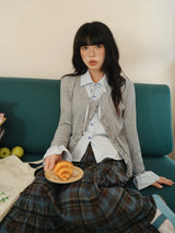 重ね着風ニット×チェックシャツ グレー 着用 ソファに座って パンを持って