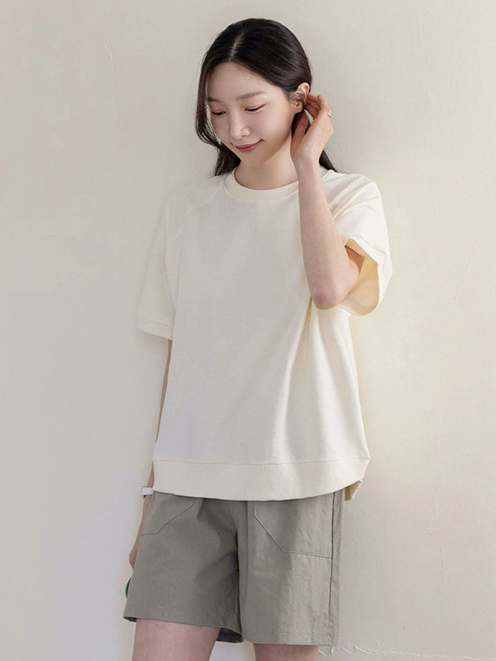クリームのラグランスリーブTシャツ 着用 耳に触れて