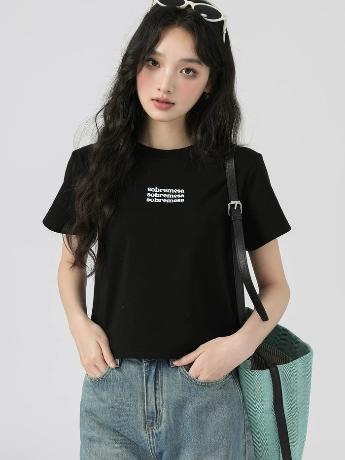 胸元に英字ロゴの入ったブラックの正肩 半袖Tシャツ 着用