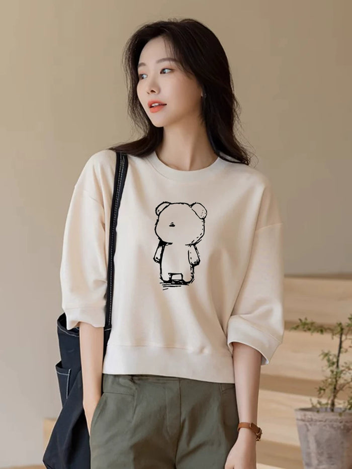 クマのイラストのクリームTシャツ 着用 バッグを持って