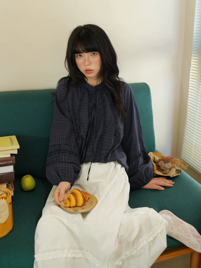 ネイビーのチェック柄パフスリーブブラウス 着用 ソファで座って