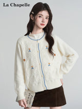 オフホワイトの刺繍フラワー ニットカーディガン 着用 本を持ったポーズ