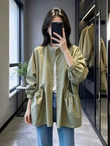 アーミーグリーンのノーカラー シャツジャケット 着用 スマホで撮影するポーズ