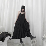 ブラックのクリンクル ロングキャミワンピース 着用 裾を持ったポーズ