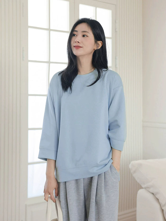 スカイブルーの中袖Tシャツ 着用 窓辺で立つ全身