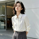 ホワイトのシフォン調シャツ 着用 カフェの前で