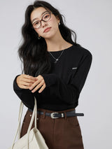 ブラックのワッペン付き 長袖Tシャツ 着用 バッグを持ったポーズ