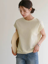 クリームのTシャツ 着用 帽子を手に持って