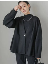ブラックのダンボールニット ペプラムジャケット 着用 髪に手を添えたポーズ