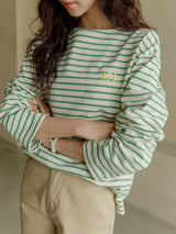 グリーンのボーダーTシャツ 着用 腕を組んで 胸元の刺繍