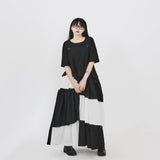 白黒のロングジャンパースカート 着用 手を添えた立ち姿