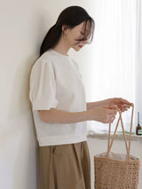 クリームのTシャツ 着用 バッグを持つ手元