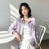 ライトパープルの長袖シャツ 着用 テーブルにもたれて