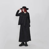ブラックのアシンメトリーシャツ 着用 帽子に手を添えた着こなし