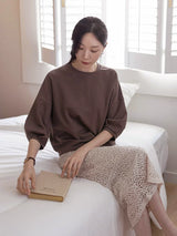 ブラウンのコットンTシャツ 着用 ベッドに座って