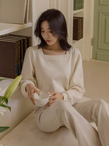 クリームの長袖Tシャツ 着用 座ってカップを持って