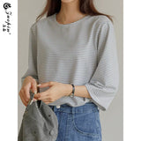 ブルーのピンストライプTシャツ 着用 キャップを持って
